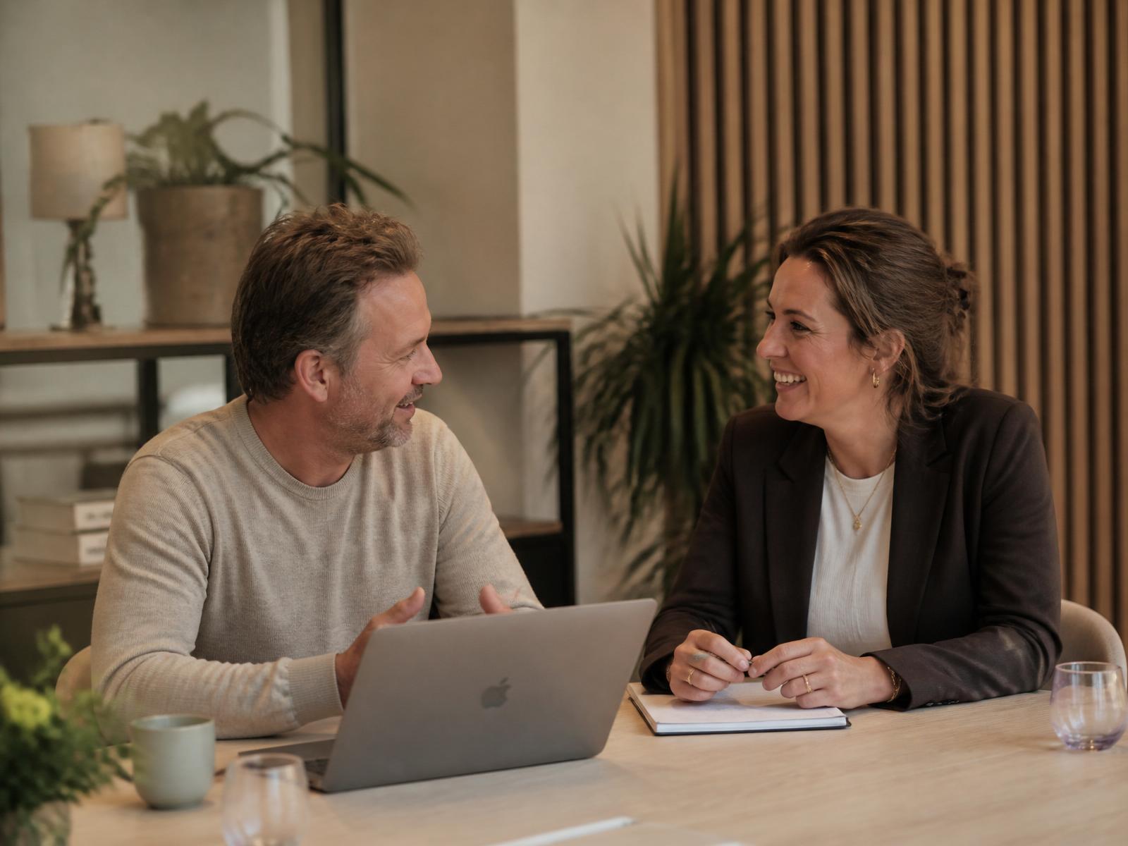 Ondernemer en HR-professional in gesprek in een warm, licht kantoor